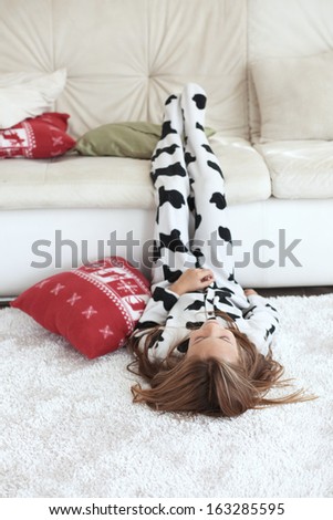 Portrait of child in soft warm cow print pajamas playing at home