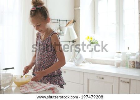 7 years old school girl cooking at the kitchen, casual lifestyle photo series