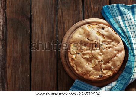 Closeup photo of holiday apple pie on rustic wooden background, top view point
