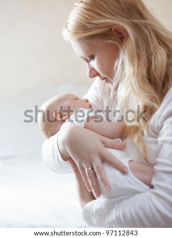 Similar – Foto Bild Blonde Mutter hält ihr bezauberndes fröhliches kleines Baby im Arm. Nettes Kleinkind Kind in die Kamera schauen und lächelnd zu Hause