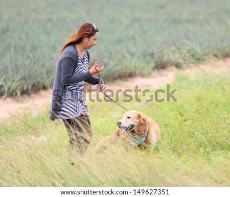 young woman walking in the park with a golden retriever dog  Asian woman smiling happy. Photo from Thailand Rayoung Province