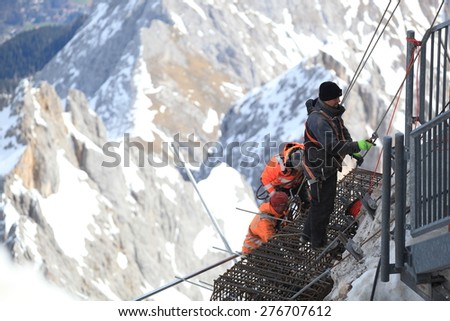 GARMISCH PARTENKIRCHEN , GERMANY  ,  April 16 , 2015  Mountain working team members in dangerous area ,they are working look like rescue as they evacuate an injured climber from a rock pinnacle.