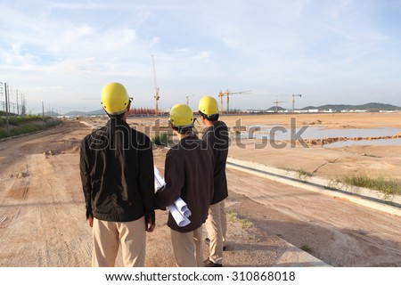 Business partners discussing a blueprint of the building at the construction site