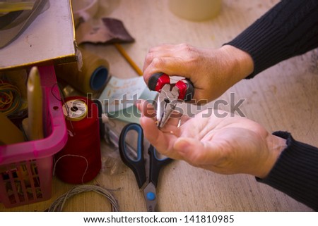Woman working with pliers and other tools