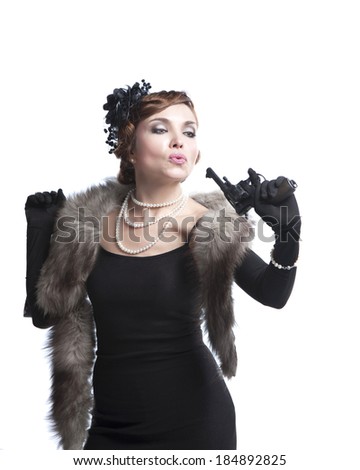 woman in retro style, wearing a black dress, fur and beads with gun ,on white background