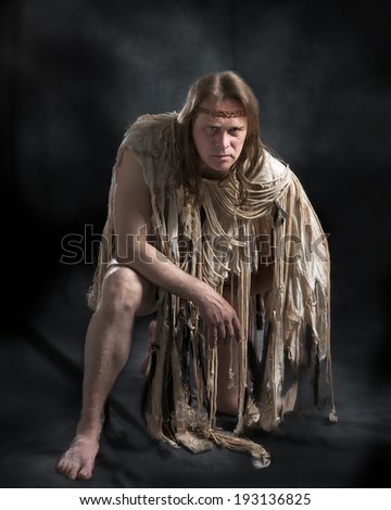man with long hair in the ancient character posing on a black background