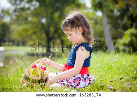Little European girl holding basket of flower