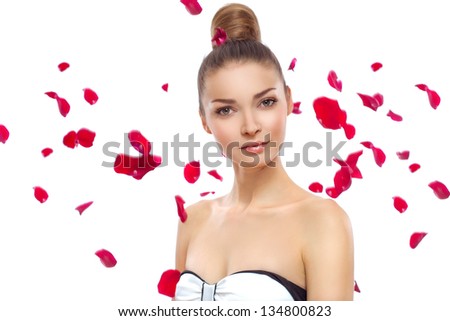 portrait of a beautiful young girl with flying rose petals on white background