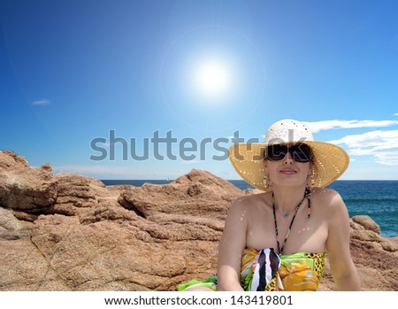 woman lying on the rocks on the beach on a summer day