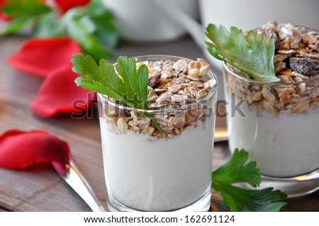 small glasses of plain yogurt with muesli and raisins