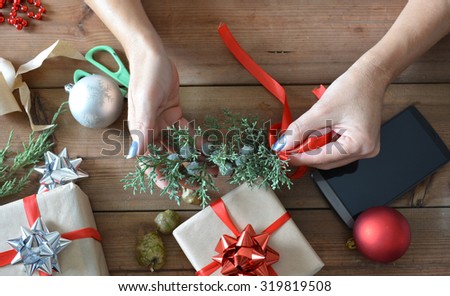 preparing Christmas hand with paper, scissors and red ribbons