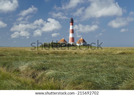 Landscape with salt meadows and the light house Westerhever (North Frisia, Germany, Schleswig Holstein) located near the coast of the North Sea taken on a sunny morning.