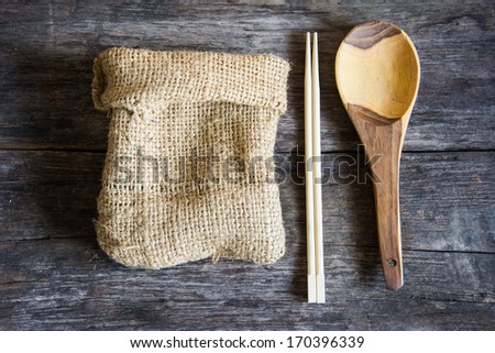 empty wooden board, ladle and sack on a table.