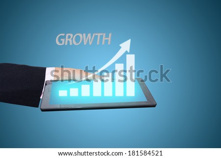 businessman hand holding a growth graph on tablet.