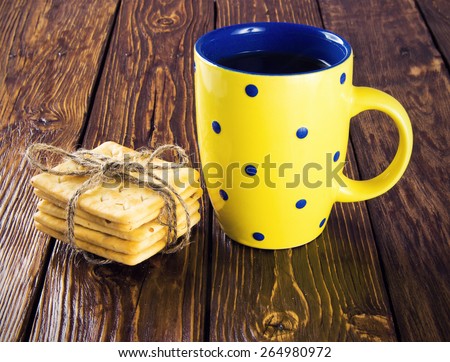 tea cup yellow square cookies on a wooden table