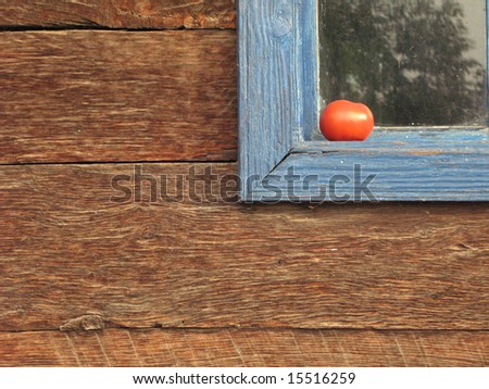 Old wooden house detail close-up, tomato on window sill