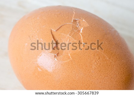 Cracked egg shell in the middle of egg on wooden table
