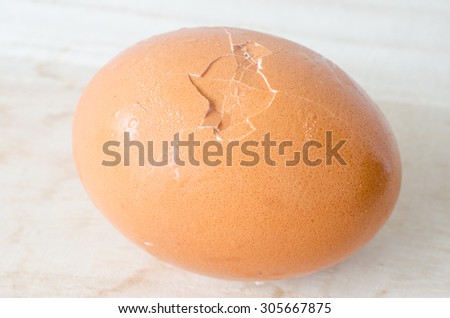 Cracked egg shell in the middle of egg on wooden table