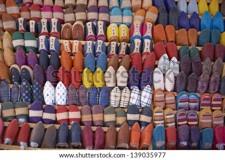 Colorful display of traditional leather slippers for sale in the souk of Fes in Morocco.