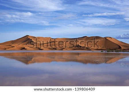 Sand dunes reflected in rainwater lakes in the Sahara Desert of Morocco in North Africa