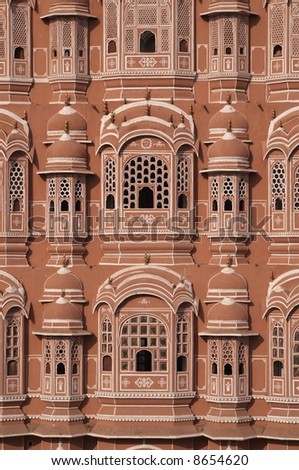 The Hawa Mahal or Palace of the Winds. Ornate pink and gold facade built to allow the ladies of the harem to view the streets below without being seen. Jaipur, Rajasthan, India