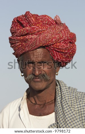 Rajasthani man with bright red turban and bushy mustache at the Nagaur Cattle Fair in Rajasthan, India