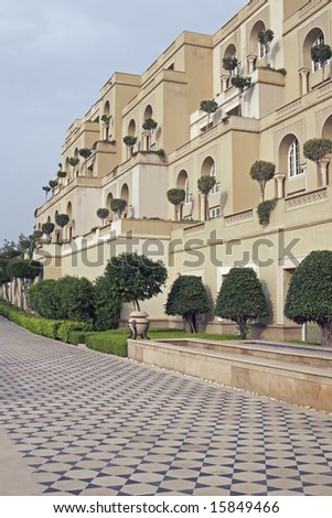 Luxury hotel built in the traditional Mughal style. Honey colored sandstone building with ornate tiled path. Agra, India