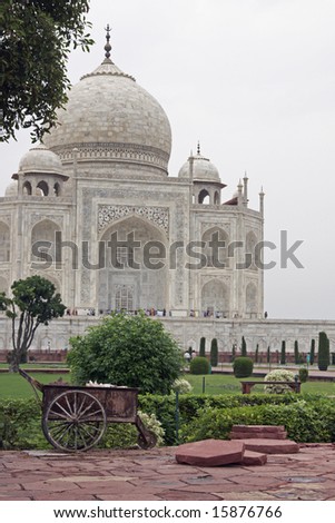 Taj Mahal. Old rustic wheelbarrow in the gardens infront of a white marble islamic tomb. Agra, Uttar Pradesh, India