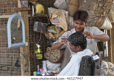 DELHI, INDIA - APRIL 12: Man have his hair cut at a street barbers on April 12, 2009 in Old Delhi, India.