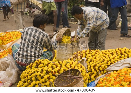 CALCUTTA - DECEMBER 18: Man buys a bag of flowers at the flower market on 18 December 2008 in Kolkata (Calcutta), West Bengal, India.