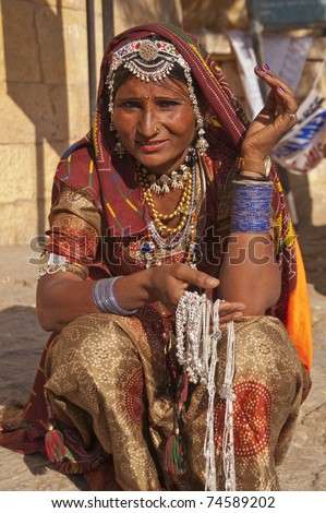 JAISALMER, INDIA - FEBRUARY 3: Unknown Indian lady in traditional outfit selling silver necklaces on February 3, 2007 at Jaisalmer Fort during the annual Desert Festival in Rajasthan, India