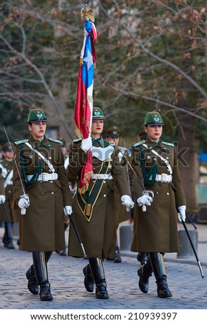 SANTIAGO, CHILE - AUGUST 8, 2014: Members of the Carabineros marching with a ceremonial flag as part of the changing of the guard ceremony at La Moneda in Santiago, Chile