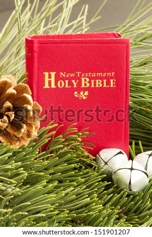 Red Bible and Silver Bells Small red Bible, New Testament with silver sleigh bells and pinecone. Bible. pinecone and bells are are surrounded by fresh cut pine branches.