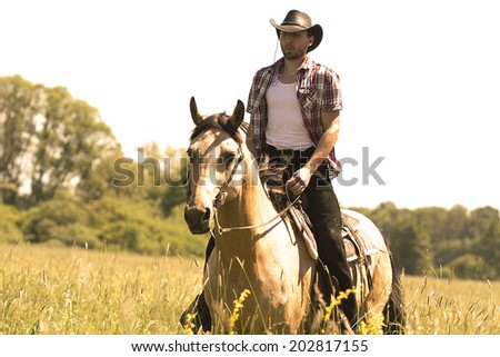 young cowboy man ridig with horse