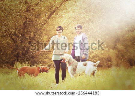 young love couple man and woman kiss on walk with dog in autumn nature