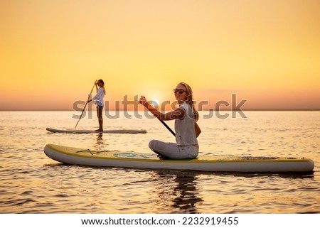 Similar – Image, Stock Photo Woman with paddleboard on shore in sea