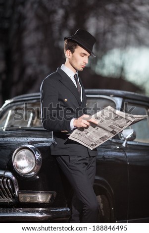 man with a retro car man with a retro car. reading a newspaper