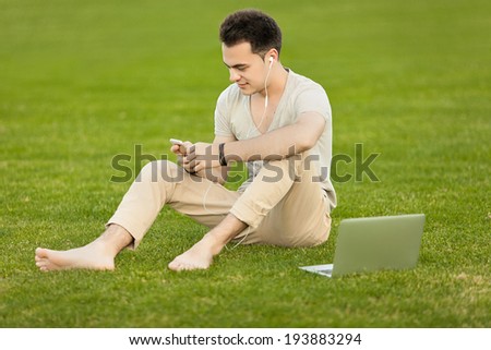 Young man with laptop in the park