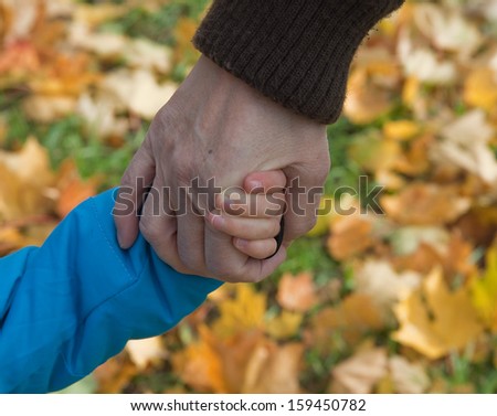 Grandmother lead by the hand grandson outdoor