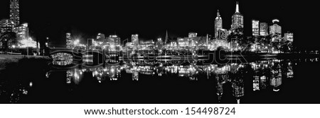black and white panoramic skyline of melbourne at night reflected in the yarra river