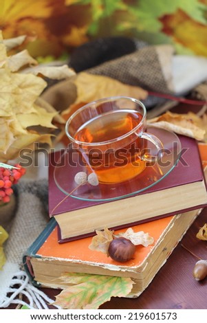 Still life with tea, books and autumn leaves