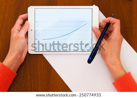 Female holding tablet with positive chart