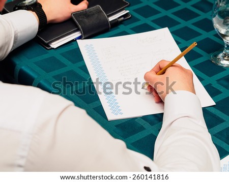 Making notes. Close-up of man in formalwear writing something in his note pad