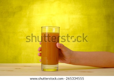 Children\'s hand is holding peach juice