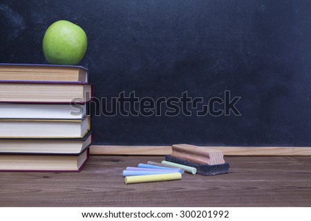 books with apple, eraser and chalk