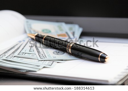 Ball pen against banknotes.Horizontally