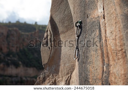 Quick draw hanging on rock wall in valley