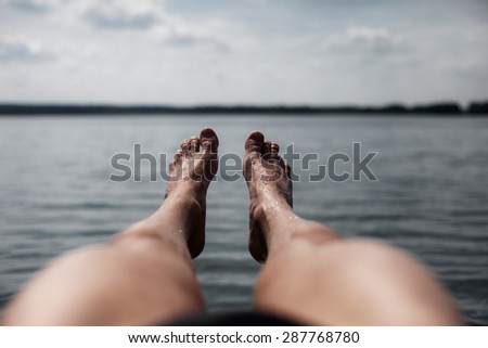 Legs and feet on a big and calm lake