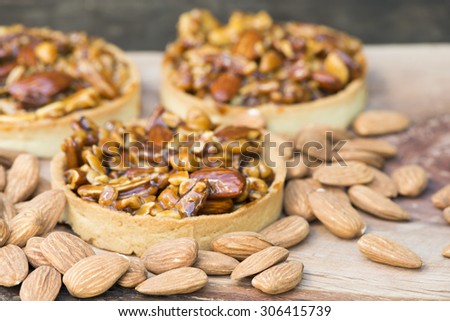 Tart with nuts almonds and caramel on a rustic background