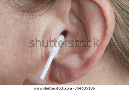 Cotton swab in the ear close up